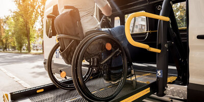 Man in rolstoel op platform om op bus te stappen